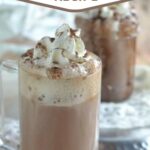 hot chocolate in a glass mug with whipped cream on top